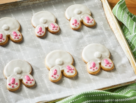 Bunny shaped cookies sitting on a parchment lined baking sheet