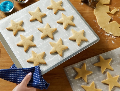 Star shaped sugar cookies on a parchment lined cookie sheet