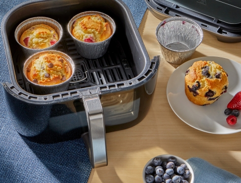 3 air fryer cups filled with muffins sitting in an air fryer basket