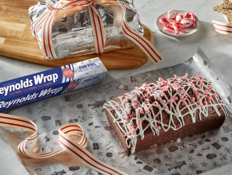 mocha peppermint bread sitting on a sheet of aluminum foil with a wrapped loaf of bread behind wrapped in a bow