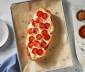 Pepperoni pizza sitting on a parchment lined baking sheet
