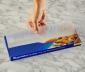 Person pulling a sheet of parchment from the package