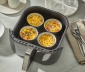 4 air fryer cups filled with egg bites sitting in an air fryer basket