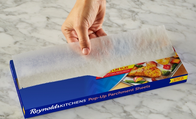 Person pulling a sheet of parchment from the package