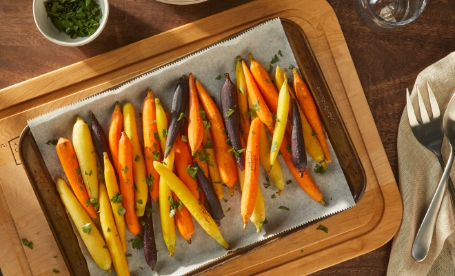Roasted carrots sitting on a parchment lined baking sheet 