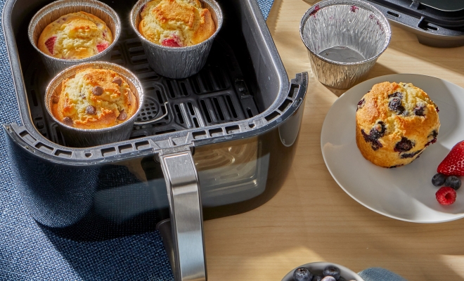 3 air fryer cups filled with muffins sitting in an air fryer basket 