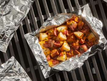 diced potatoes in a foil packet sitting on the grill