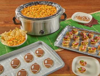 football themed appetizers and desserts sitting on a decorated table