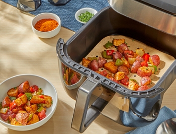 Crispy air fryer breakfast potatoes sitting in a parchment lined air fryer basket