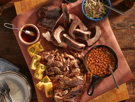butcher paper lined cutting board topped with ribs, brisket and pulled pork