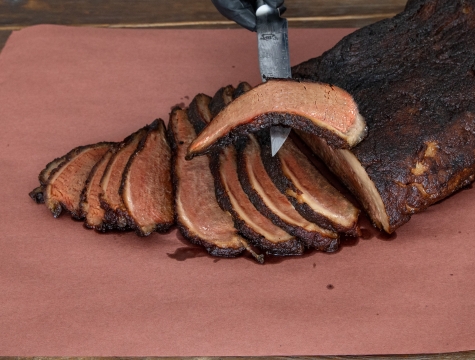 sliced brisket sitting on a sheet of Reynolds Kitchens Butcher Paper