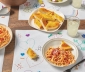 placemats made out of countertop prep paper sitting at a dinning table and topped with plates of spaghetti