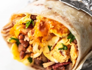 breakfast burrito partially wrapped in aluminum foil